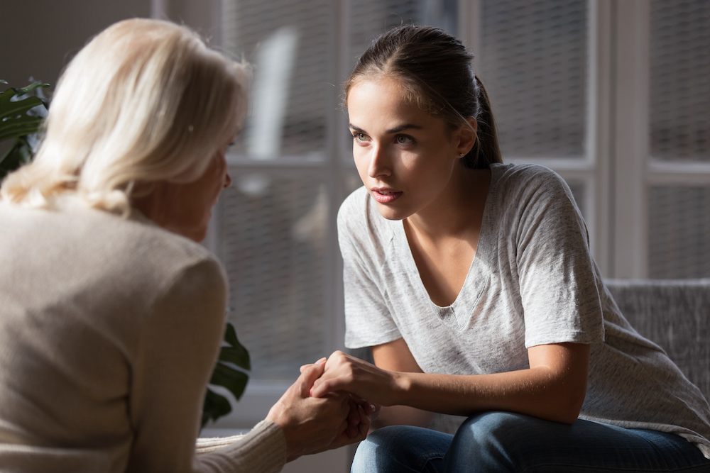 An adult woman talks with her senior mother about moving to one of the memory care communities near me