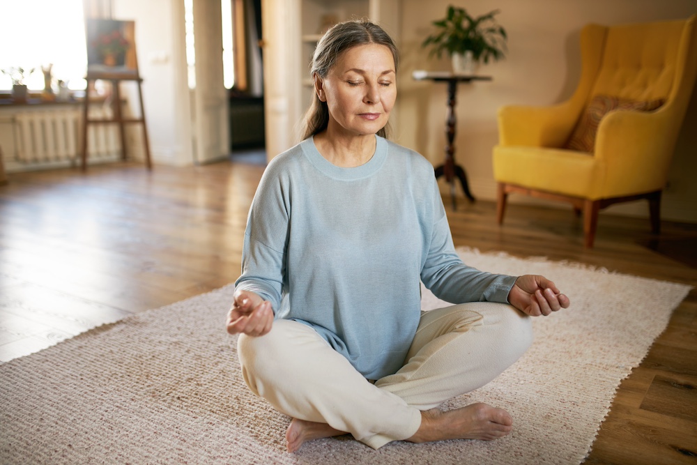A senior woman practicing meditation at the San Juan Capistrano memory care for seniors