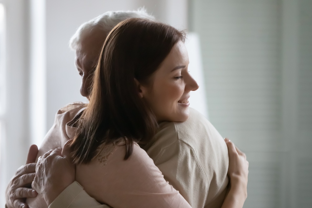 Daughter hugging elderly father warmly